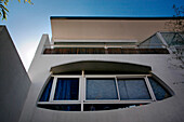 Modern facade stucco finished with white aluminium balcony and eye-shaped window