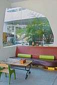 Ledersitzgruppe mit Tisch in einem Wintergarten mit weißen Fenstern, der den Außenbereich mit dem Innenbereich verschmelzen lässt