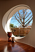 Drums at large circular window in room with red eucalyptus flooring