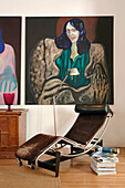 Black leather recliner and stack of magazines with modern artwork