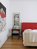 Modern art in bedroom with red headboard