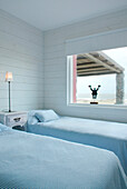 Twin beds and window of coastal beach house