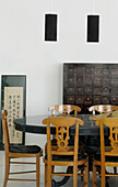 Esszimmer mit nussbaumfurnierten, mit schwarzem Samt bezogenen Stühlen und einem antiken Tisch mit Ulmenschrank zur Aufbewahrung des Geschirrs