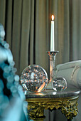 Glass paperweights with silver candlestick holder on marble pedestal based side table