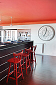 Kitchen with red ceiling and oversized clock