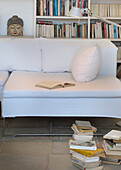 Open book on white sofa with desk lamp