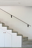 Concrete stairs with metal hand rail and under stairs storage