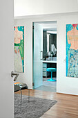 Blick aus dem Schlafzimmer mit modernem Kunstwerk durch die Tür zum eigenen Bad