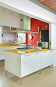 Küche mit roter Wand und gelben Formica-Arbeitsplatten