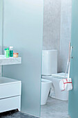 Badezimmer mit abgeschirmtem Carrara-Marmor-Waschbecken und offener Tür zu Toilette und Bidet