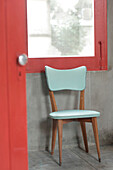 Aquamarine chair found at auction under red window frame