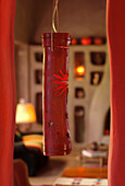 Red cane lamp hanging from a niche