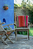 Wood chairs on patio terrace with Mexican blanket