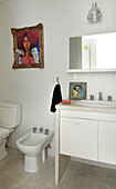 White ceramic wash stand and bidet in tiled bathroom