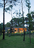 Lit building exterior set in woodland