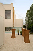 Moderne Gebäudefassade mit überdimensionalen Pflanzkübeln auf Kies