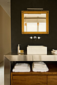 Schwarzes Bad mit Ablage unter dem Waschbecken und vergoldetem Spiegel