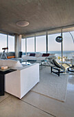 All white living room with large windows concrete ceiling and furniture of 20th century Design