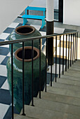 Concrete staircase with oversized pottery urns and checked floor