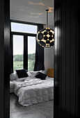 Avantgardistische Deckenleuchte im kontrastreichen schwarz-weißen Schlafzimmer