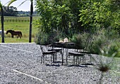 Outdoor table and chairs in backyard of modern farm house, Uruguay