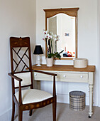 Antique wooden chair at dressing table with orchid