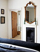 Gilt framed mirror above original fireplace in 1820s English home