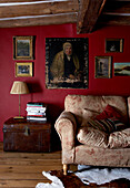 Beamed ceiling and dark red walls above sofa in 17th Century Oxfordshire living room