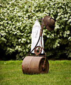 Garden roller on lawn with hat and peg bag