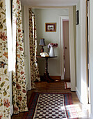 Gemusterter Teppich im Hausflur mit geblümten Vorhängen