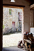 View through doorway to cobblestone farmyard and barn exterior