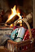 Christmas presents in basket next to open fire