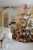 Eingepackte Geschenke unter einem Weihnachtsbaum mit rosa Dekoration