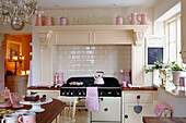 Sonnenbeschienene cremefarbene Küche mit rosa Accessoires