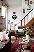 Red tulips in entrance room with wooden staircase