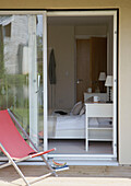 Peach deck chair on sliding door exterior of eco house bedroom