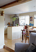 Sunlit kitchen with panelled kitchen island and grey accent 
