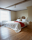 White bed cover in beamed sunlit room