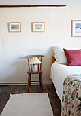 Rug on bare floorboards and bedside chair and lamp