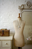 Mannequin and wooden jewellery box in whitewashed room