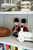 Knitted toys on shelving unit with ball and toy train