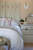 Double bed with painted chest of drawers and folding screen headboard