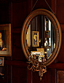 Vergoldeter Spiegel mit Girandole, der Kunstwerke reflektiert, in einem elisabethanischen Herrenhaus in Kent, das unter Denkmalschutz steht