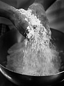 Hands sifting flour in bowl