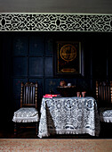 Black and white fabrics on side table and chairs in panelled Georgian farmhouse 