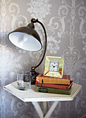 Books and lamp on bedside table in Edwardian school house conversion