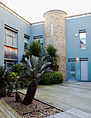 Eingang zu einem neuen Gebäude mit Palmen und Terrassen