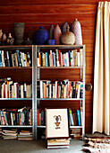 Metallgerahmtes Bücherregal mit Keramikornamenten in getäfeltem Zimmer in Masterton, Neuseeland