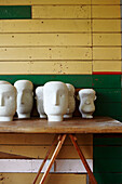 Plastercast heads on trestle table in green and yellow panelled workshop Masterton New Zealand