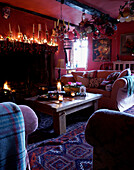 Beleuchtete Kerzen auf dem Kaminsims im Wohnzimmer eines walisischen Bauernhauses aus dem 16. Jh.